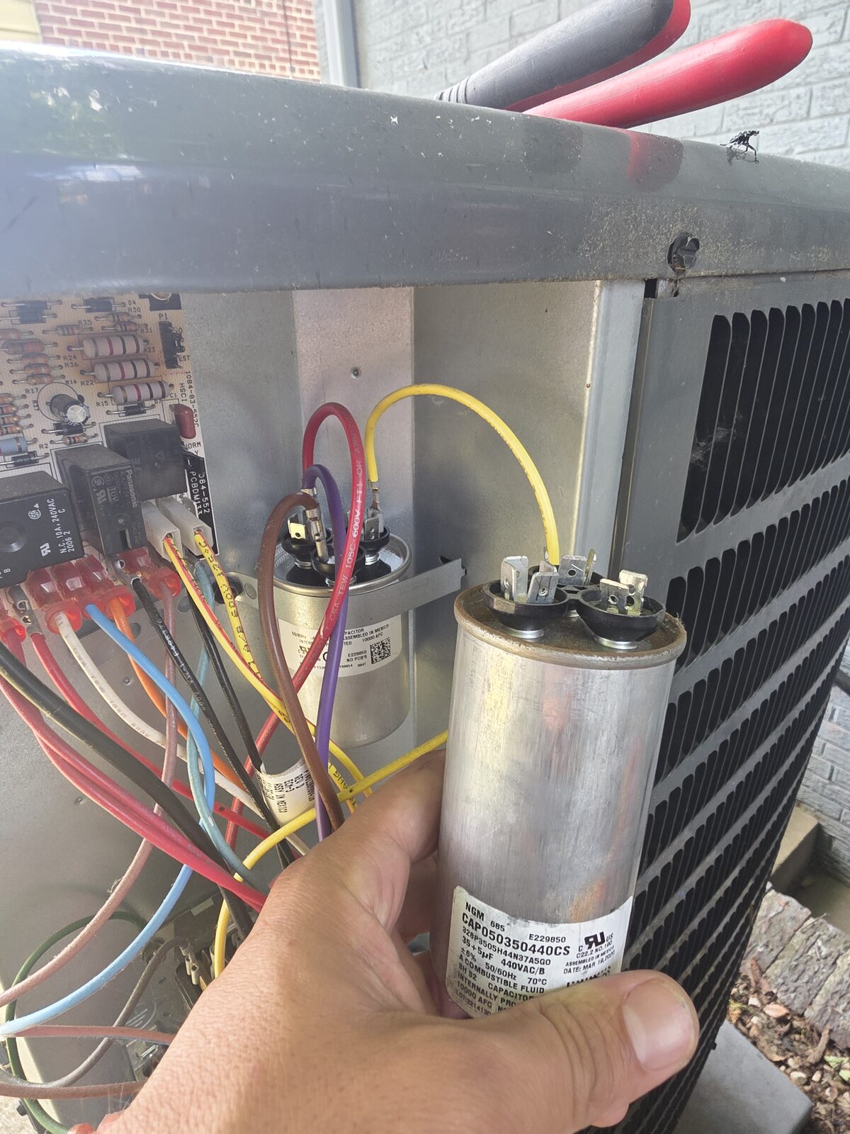 HVAC capacitor repair work on outdoor equipment